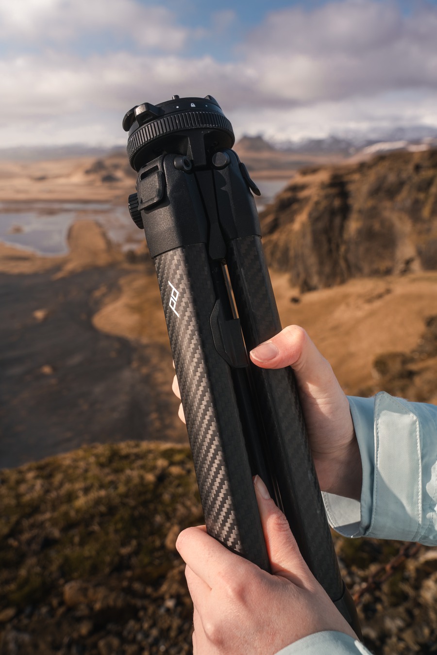 Hands adjusting a tripod overlooking Icelandic highlands — MPB Everfind